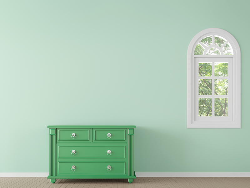 チェストと窓のある緑色の壁の部屋