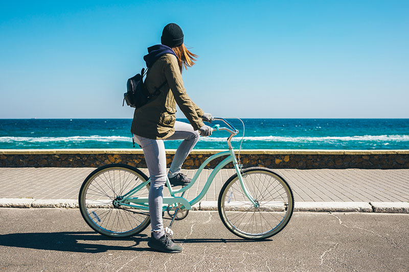 海辺をサイクリングする女性