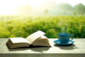 朝日の中の本とコーヒー